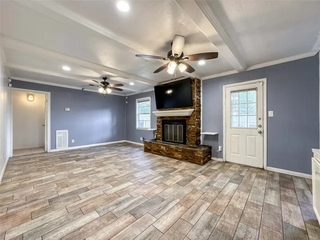 a view of a livingroom with a fireplace a chandelier and wooden floor