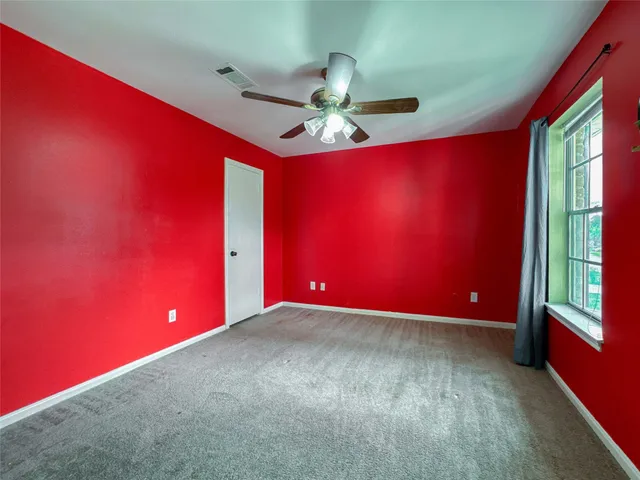 a view of empty room with window ceiling fan and fan