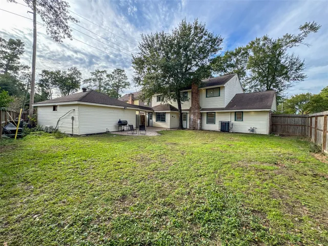 a view of a house with a big yard and large tree