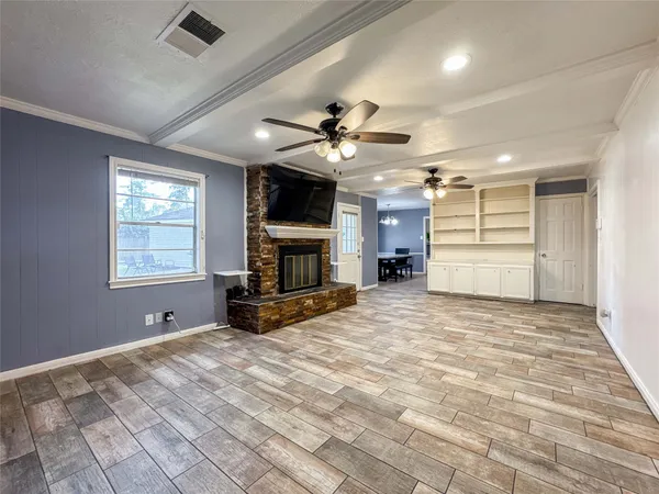 a view of an empty room with fire place and a window