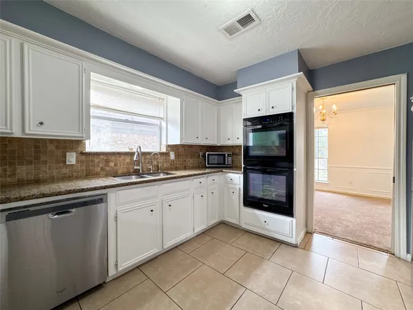 a kitchen with granite countertop a refrigerator and a sink