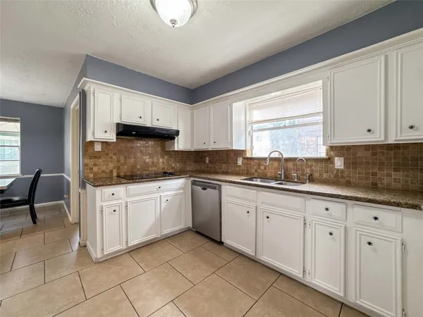 a kitchen with granite countertop white cabinets white appliances with a sink and dishwasher