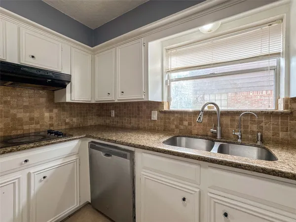 a kitchen with granite countertop white cabinets and white appliances