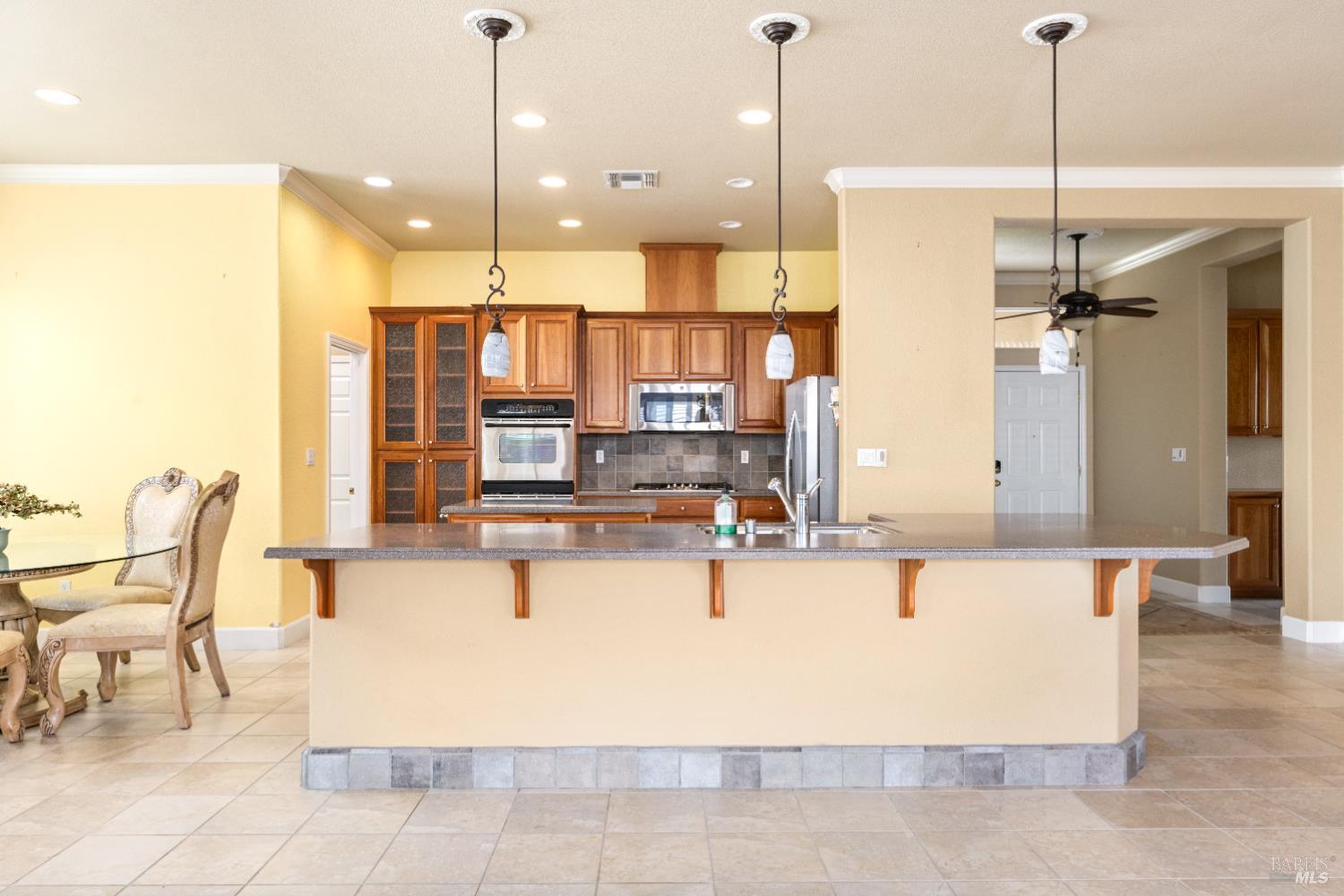 210 Southern Hills Drive Rio Vista, CA 94571 - Photo 23 of 52 a large kitchen with stainless steel appliances kitchen island granite countertop a table chairs and a refrigerator