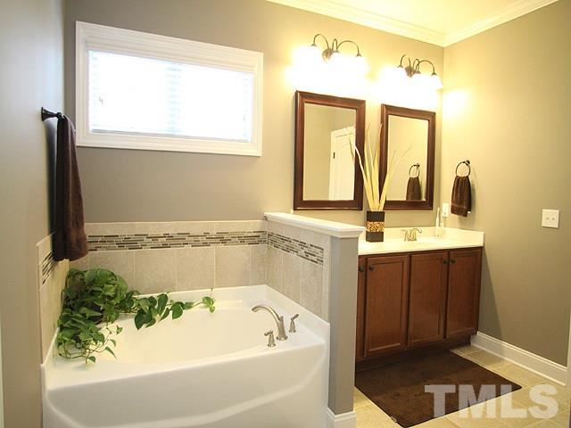 4429 Glengrove Road Raleigh, NC 27616 - Photo 8 of 13 a bathroom with a tub a sink and a window