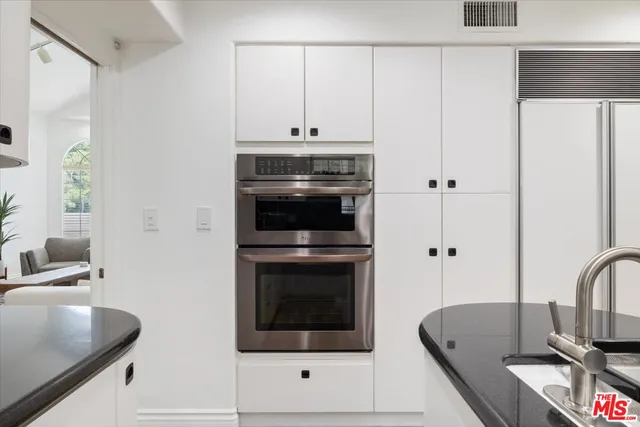 a living room with stainless steel appliances kitchen island a table and chairs