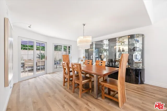 a kitchen with stainless steel appliances kitchen island granite countertop a table chairs sink refrigerator and cabinets