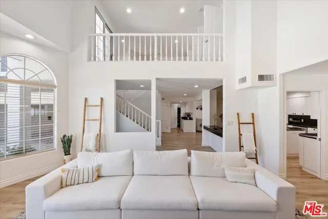 a living room with furniture fireplace and large windows