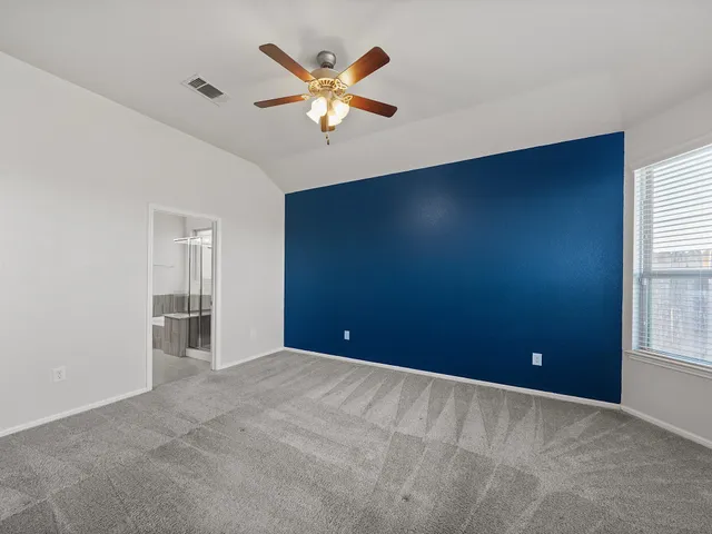 an empty room with windows and fan