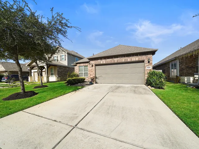 a front view of a house with a yard and trees