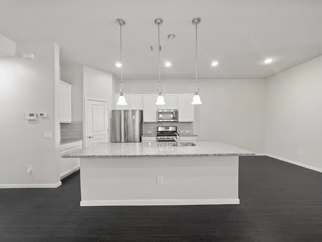 a large kitchen with kitchen island a sink stainless steel appliances and cabinets