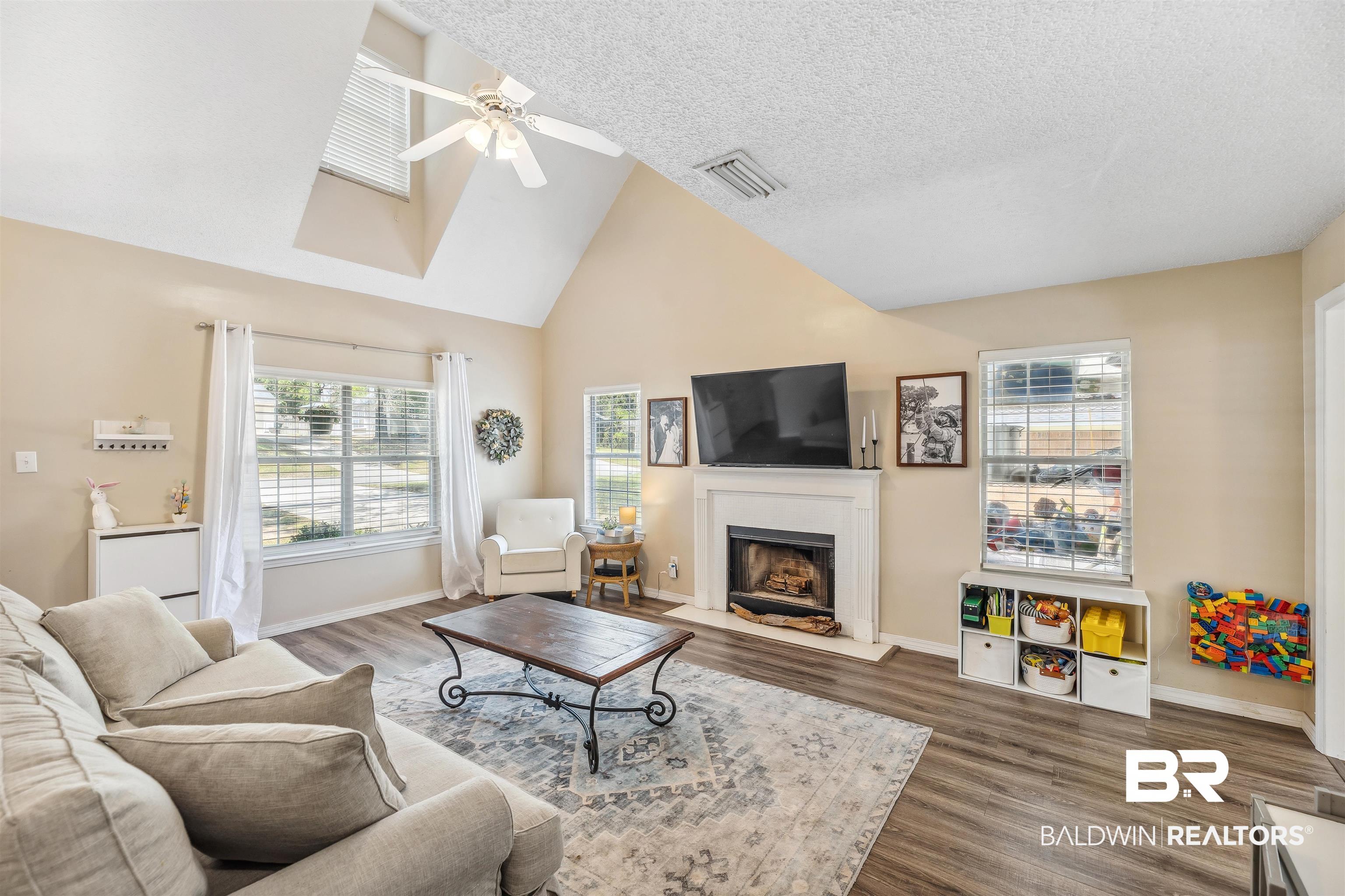 183 Richmond Road Daphne, AL 36526 - Photo 5 of 19 Living area with wood finished floors, visible vents, a ceiling fan, baseboards, and high vaulted ceiling