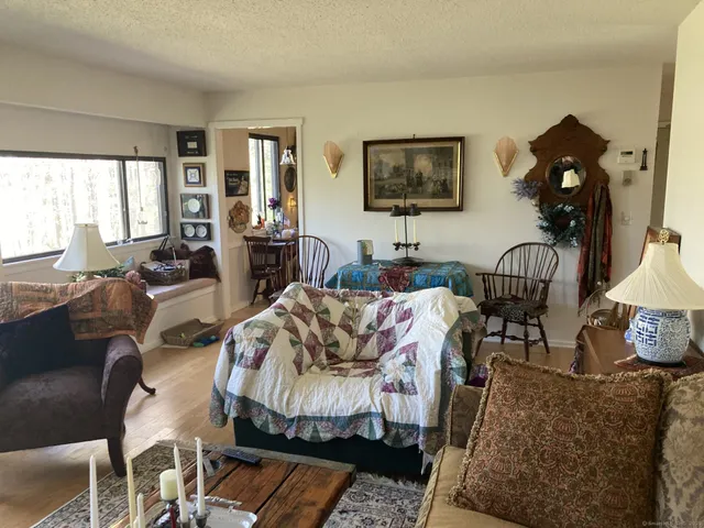 a living room with furniture fireplace and a large window