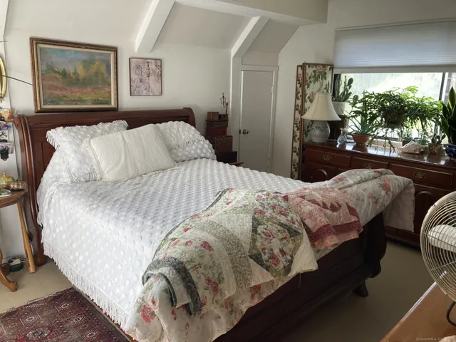 a bedroom with a bed and a painting on the wall