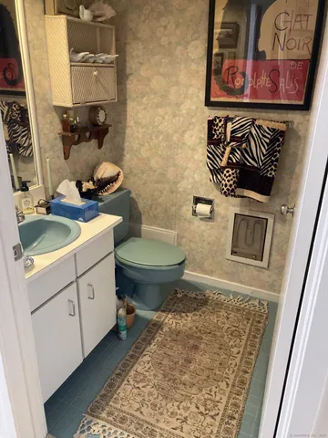 a bathroom with a toilet sink and mirror