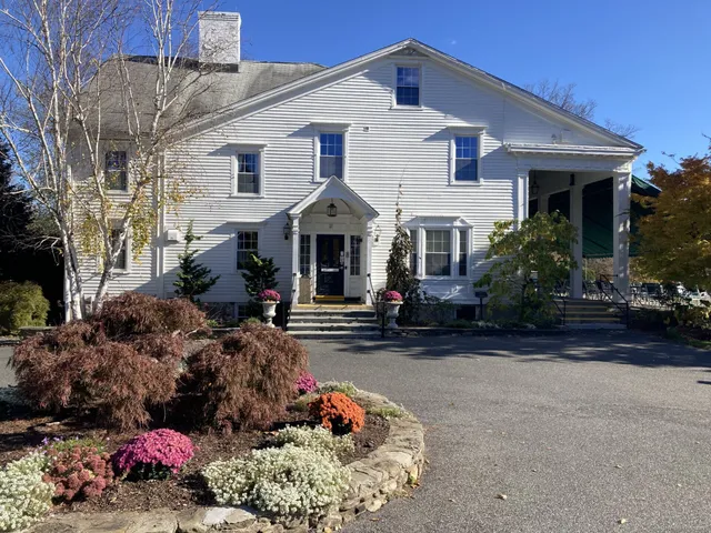 a view of a house with a yard and pathway