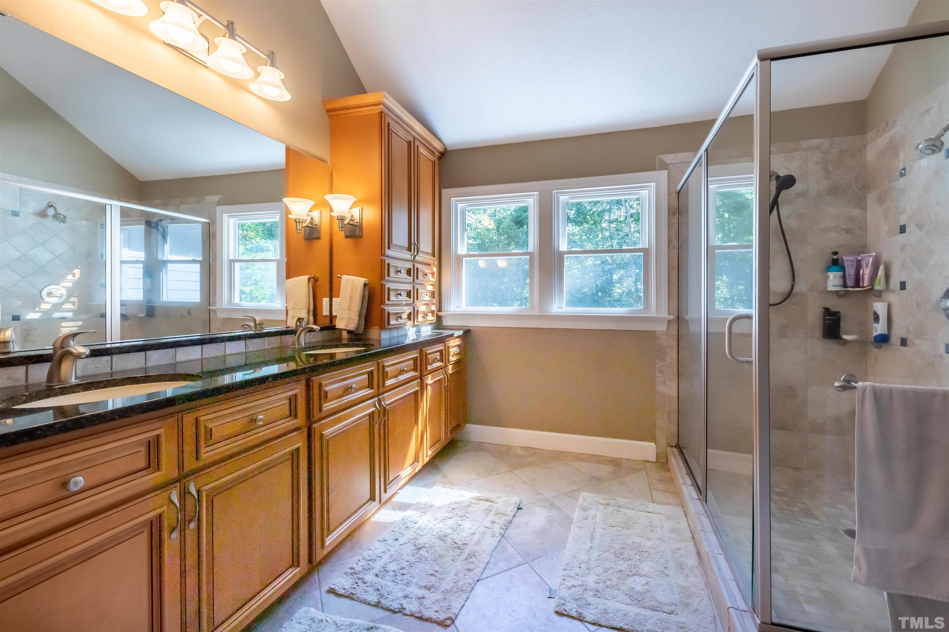 11308 Derby Lane Raleigh, NC 27613 - Photo 23 of 42 a large bathroom with a large mirror vanity and shower