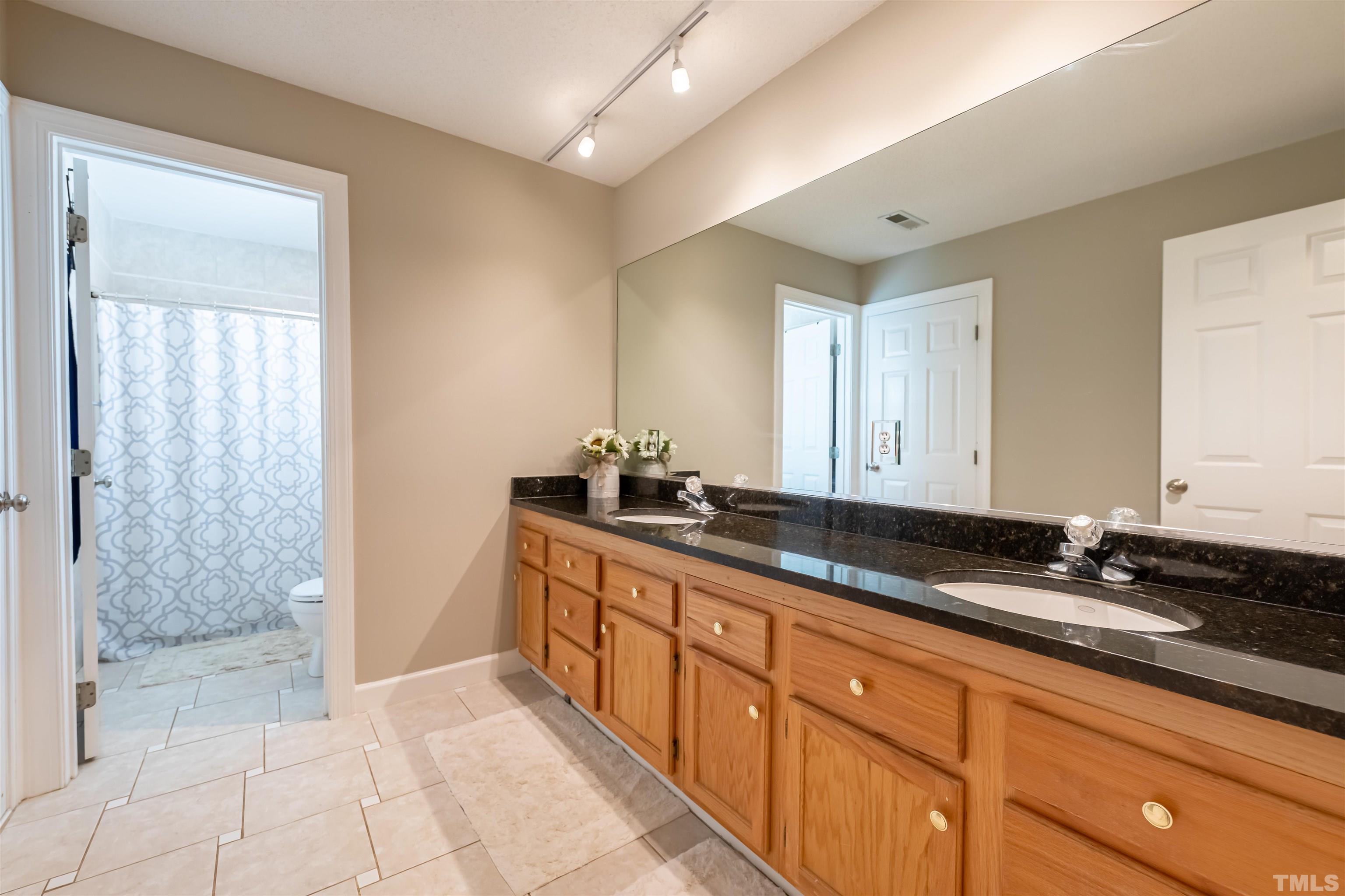 11308 Derby Lane Raleigh, NC 27613 - Photo 27 of 42 a bathroom with a granite countertop sink and a mirror