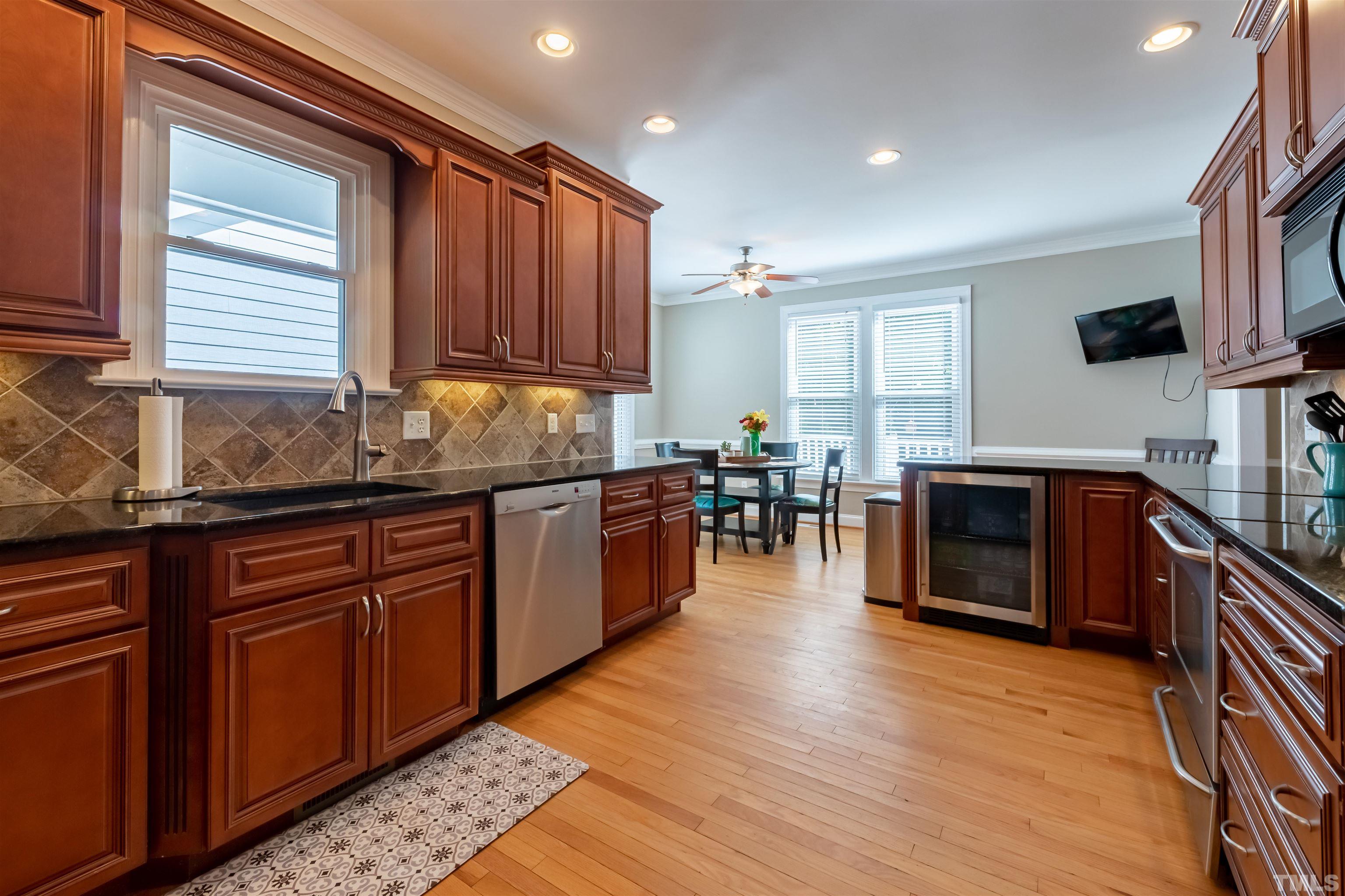 11308 Derby Lane Raleigh, NC 27613 - Photo 8 of 42 a kitchen with stainless steel appliances granite countertop wooden cabinets a sink a stove a dining table and chairs