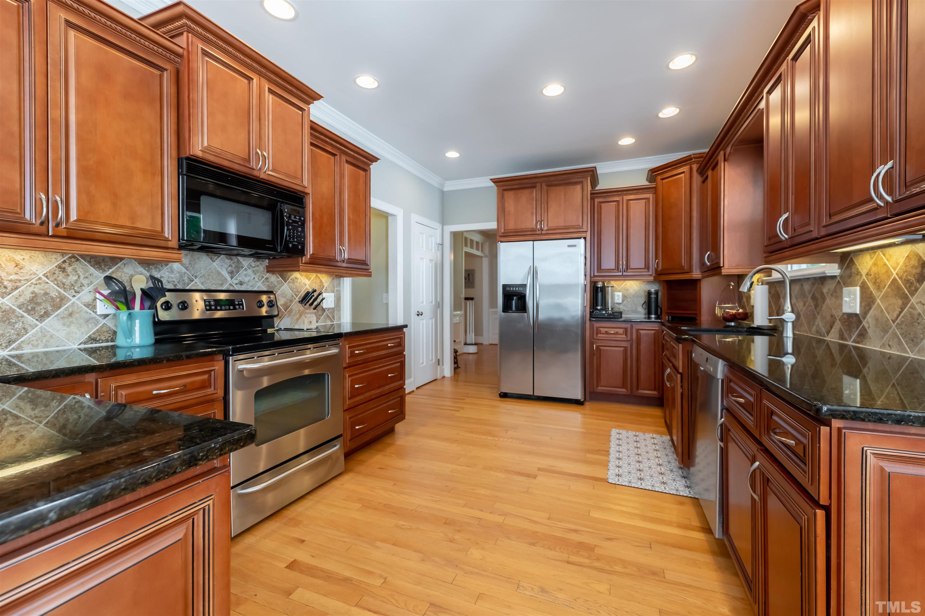 11308 Derby Lane Raleigh, NC 27613 - Photo 9 of 42 a kitchen with stainless steel appliances granite countertop a refrigerator a stove top oven a sink and dishwasher