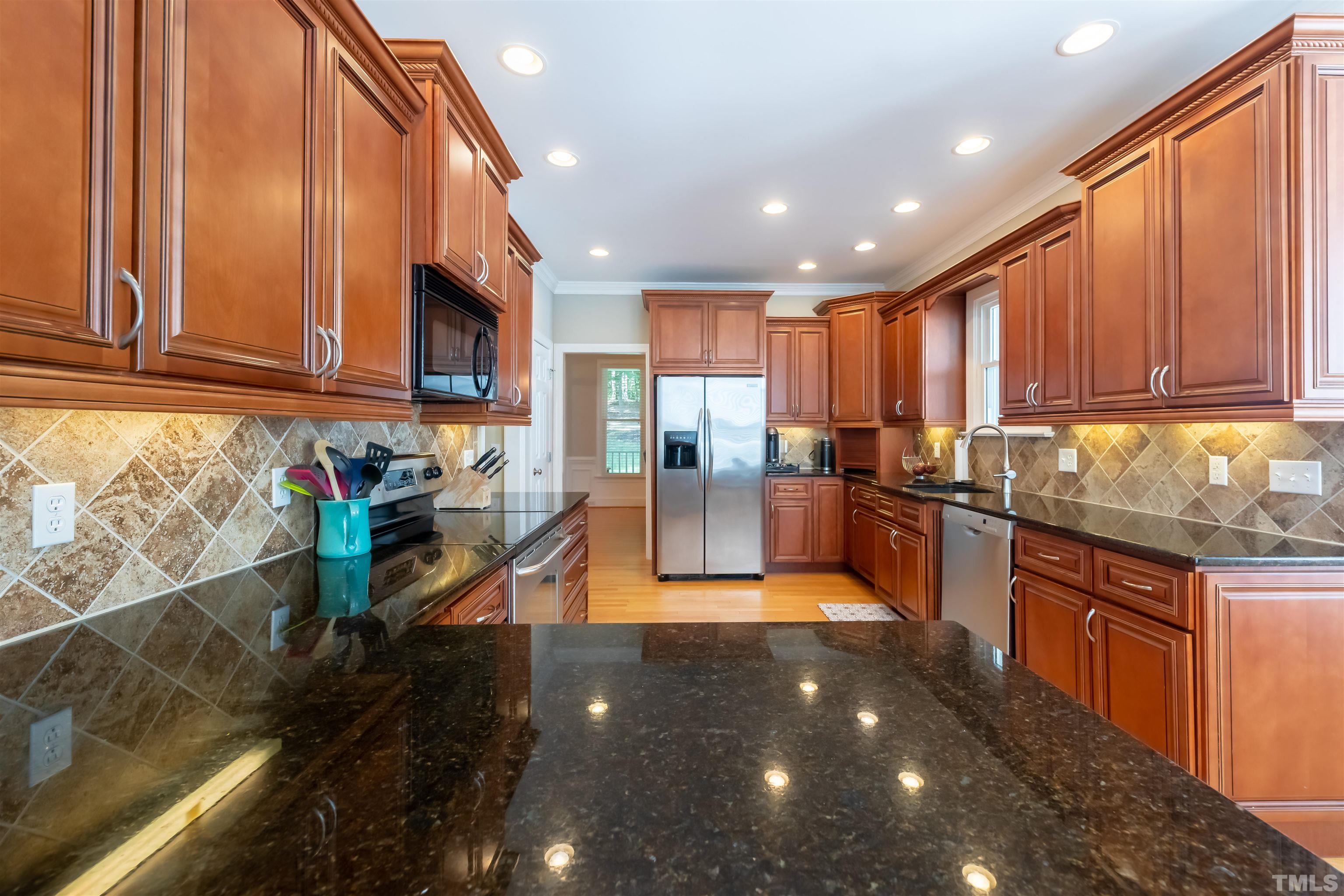 11308 Derby Lane Raleigh, NC 27613 - Photo 10 of 42 a kitchen with stainless steel appliances granite countertop a refrigerator a sink and wooden cabinets