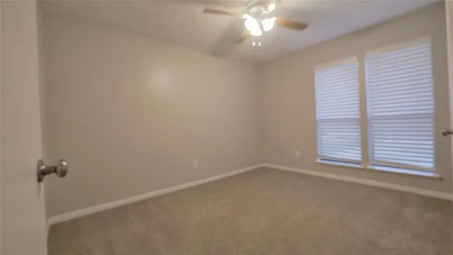 an empty room with a chandelier fan