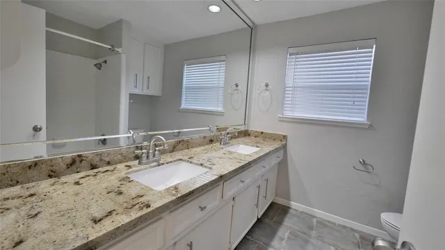 a bathroom with a granite countertop sink and a mirror
