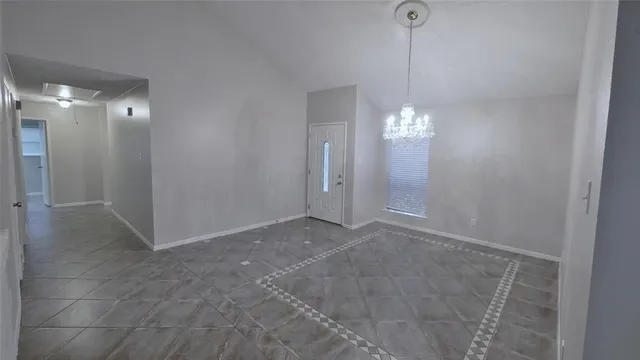 a view of a hallway with windows and chandelier