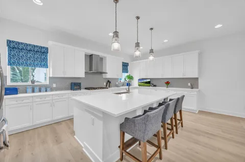 a kitchen with kitchen island a dining table and chairs