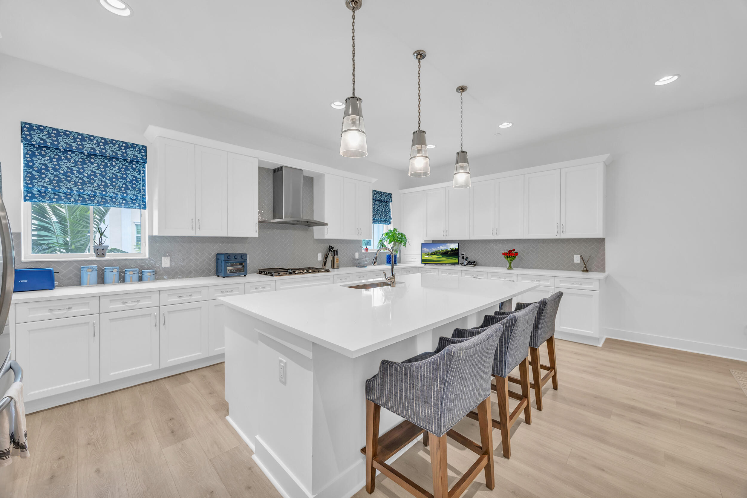 12554 Gross Pointe Road Palm Beach Gardens, FL 33418 - Photo 17 of 39 a kitchen with kitchen island a dining table and chairs