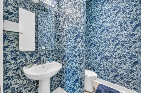 a bathroom with a sink a toilet and a mirror