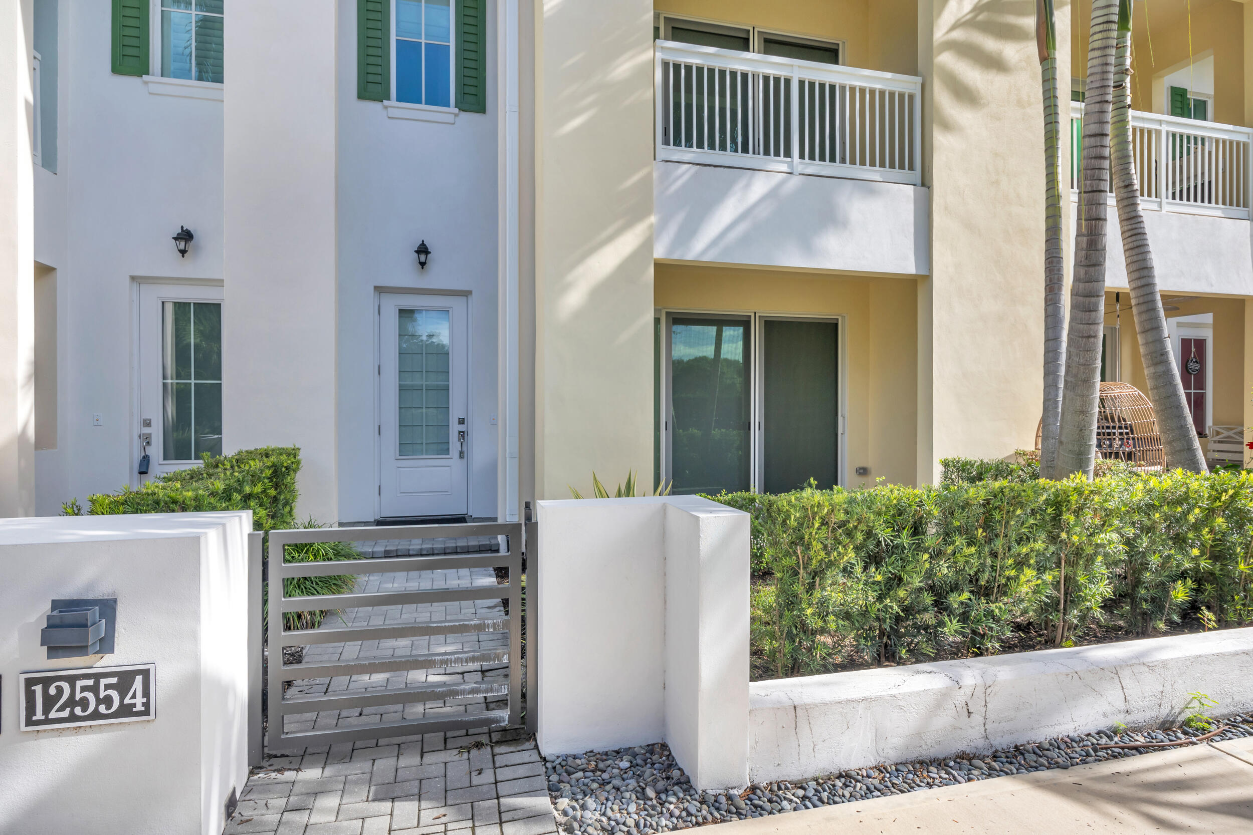 12554 Gross Pointe Road Palm Beach Gardens, FL 33418 - Photo 2 of 39 a view of a house with entryway and plants