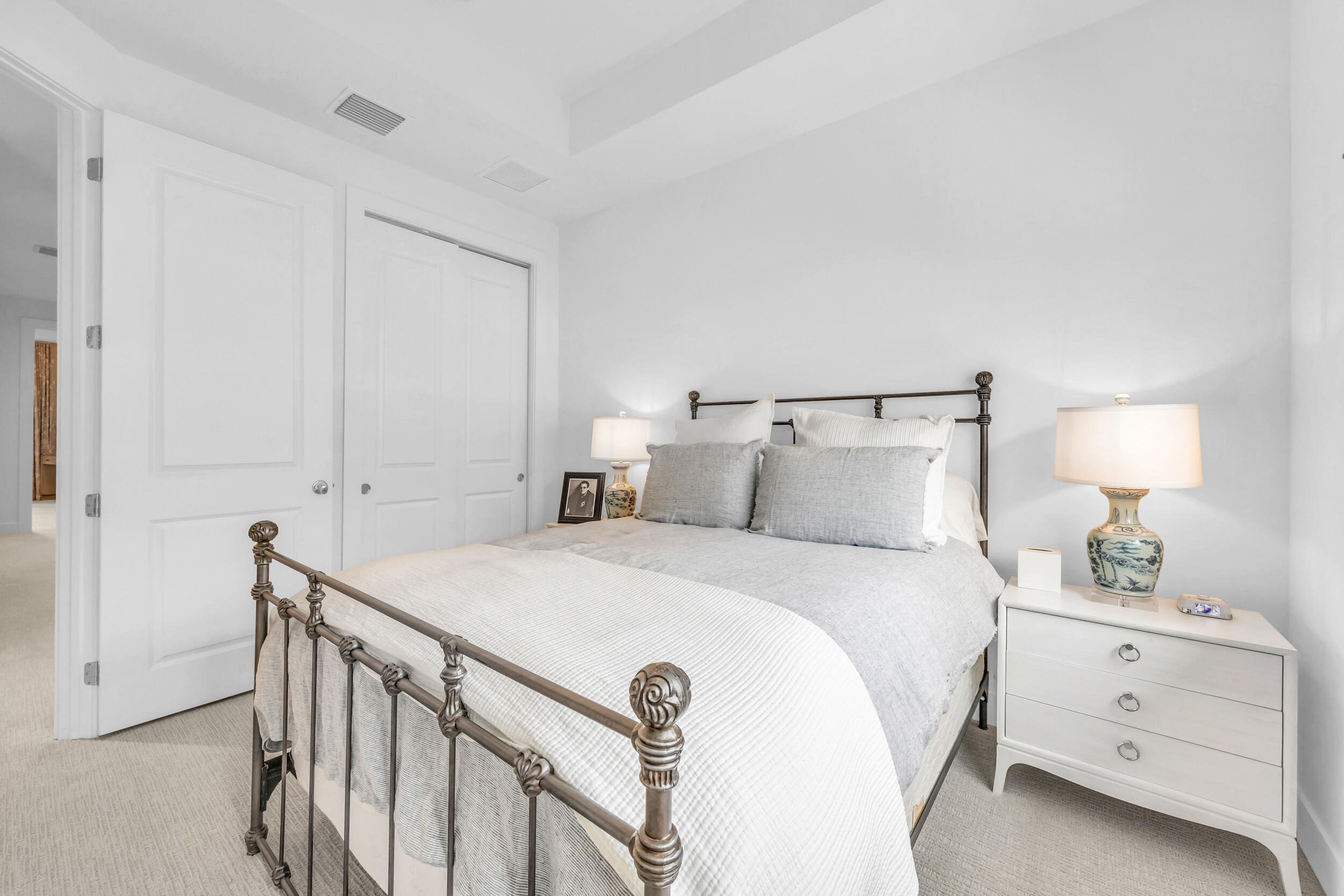 12554 Gross Pointe Road Palm Beach Gardens, FL 33418 - Photo 36 of 39 a bedroom with a bed and a night stand