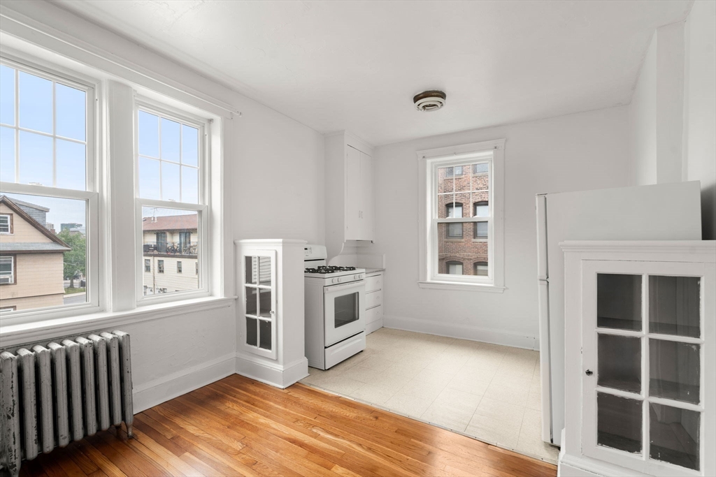 97 Chester Street, Unit 8 Boston, MA 02134 - Photo 3 of 19 a view of an empty room with a window and wooden floor