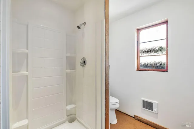 a bathroom with a toilet and a shower
