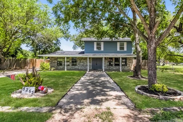 a front view of a house with a yard and potted plants