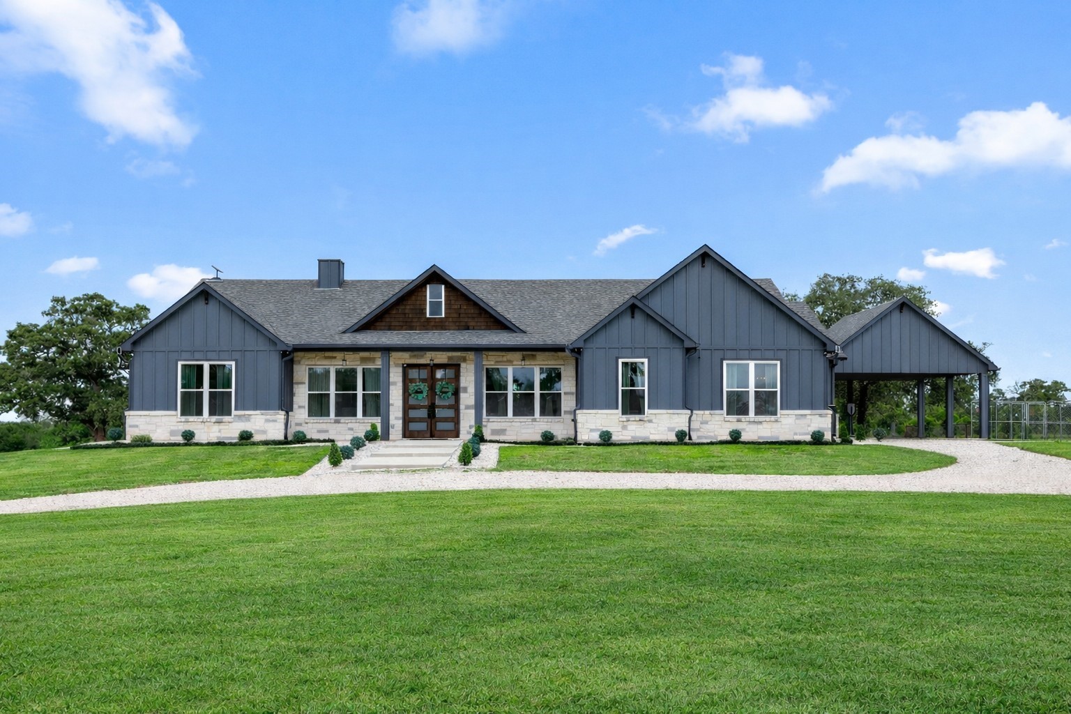 a front view of a house with a garden and trees