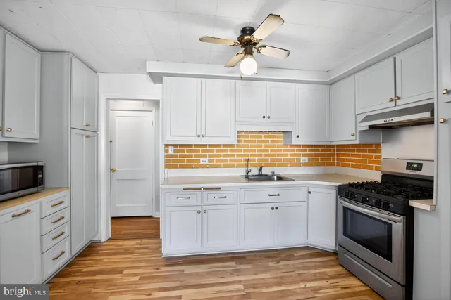 a kitchen with white cabinets and appliances