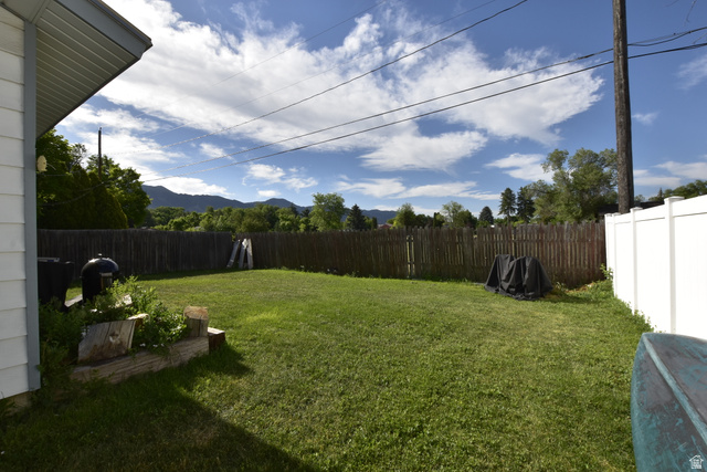 290 West 600 North Logan, UT 84321 - Photo 7 of 45 Expansive grassy backyard featuring wood fencing and a white vinyl privacy fence