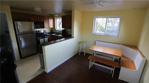 a room with stainless steel appliances furniture a refrigerator and a window