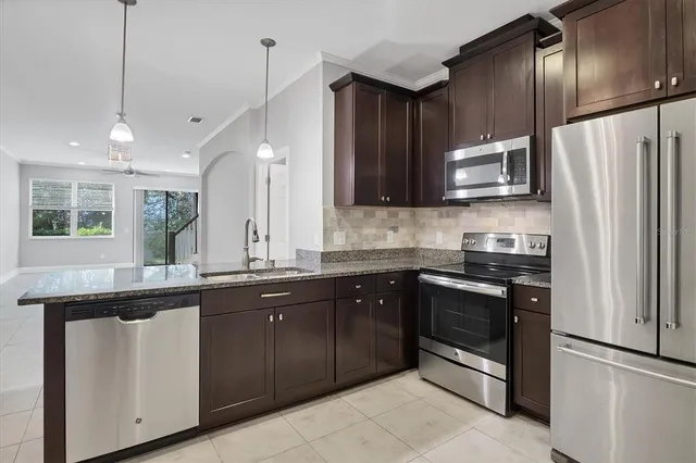 a kitchen with stainless steel appliances sink stove microwave and refrigerator