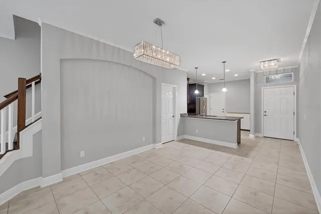 a view of an empty room with kitchen view and a window