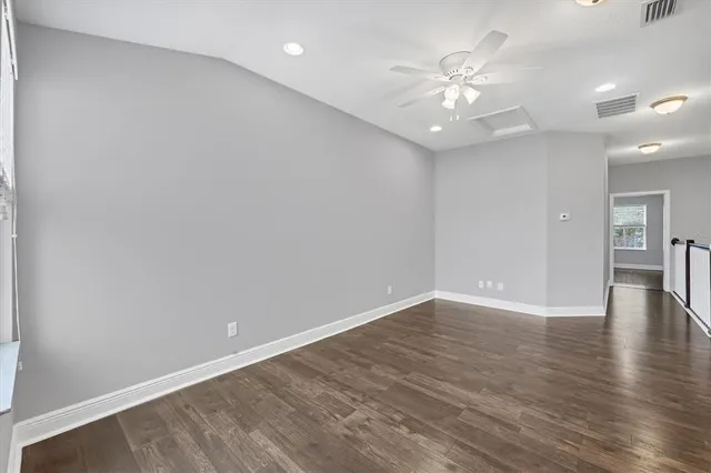 a view of an empty room with wooden floor