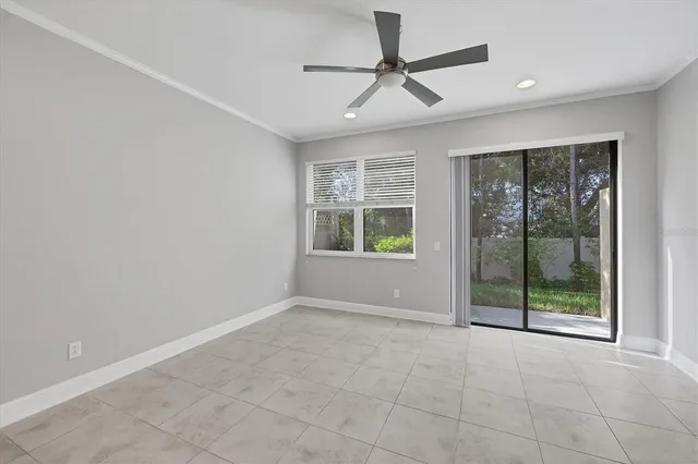 a view of an empty room with a window and a ceiling fan