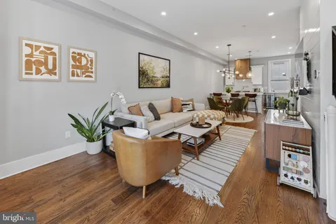 a living room with furniture a flat screen tv and a dining table