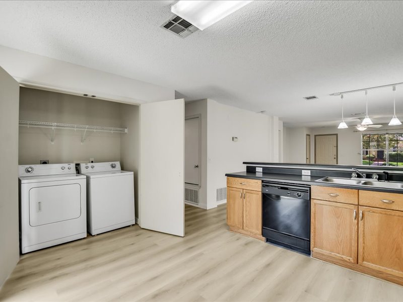 13827 Spring Heath Road Pflugerville, TX 78660 - Photo 12 of 20 An open-concept living area features a convenient laundry nook and a modern kitchen with ample counter space.