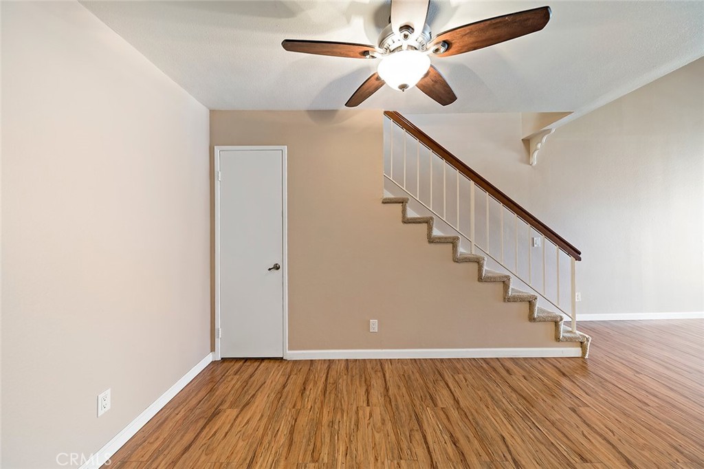 7720 Elmdale Way, Unit J Stanton, CA 90680 - Photo 8 of 18 a view of an empty room with wooden floor and a ceiling fan