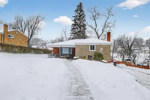 a view of a house with snow on the road