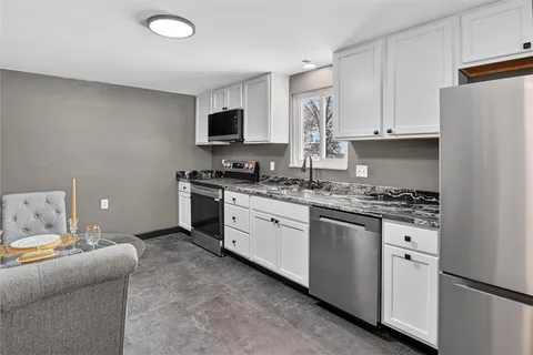 a kitchen with white cabinets and stainless steel appliances
