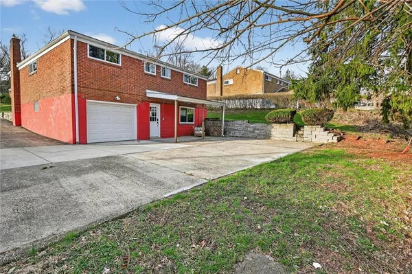 a view of a house with a yard and pathway